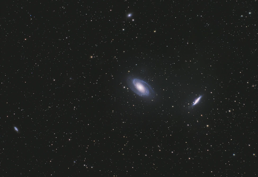 Deep space photograph showing three spiral galaxies against a starfield.