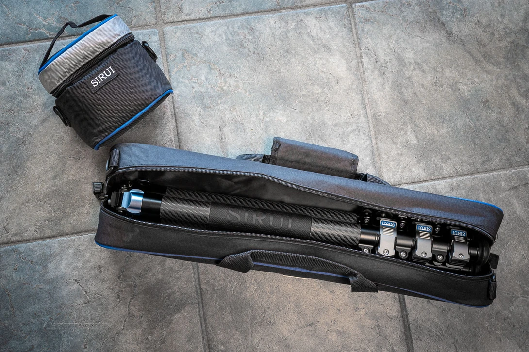 Camera slider with carbon fiber construction and accessories displayed on tile flooring.