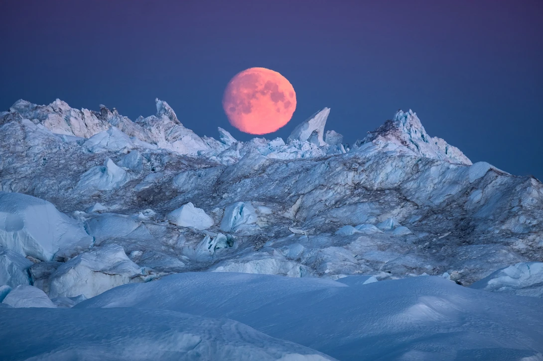 View Moon rising over Icebergs in Ilulissat Icefjord by Maria Sahai
