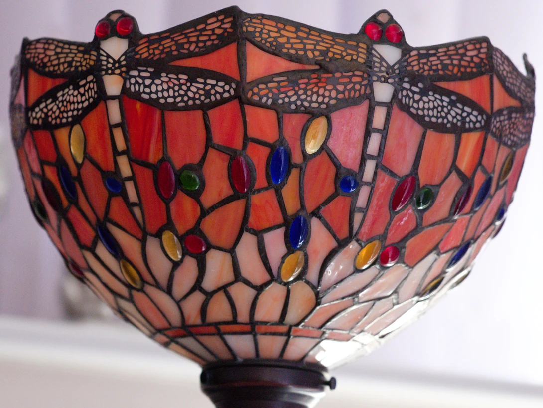 Tiffany-style stained glass lamp shade with red dragonfly motif and amber glass accents